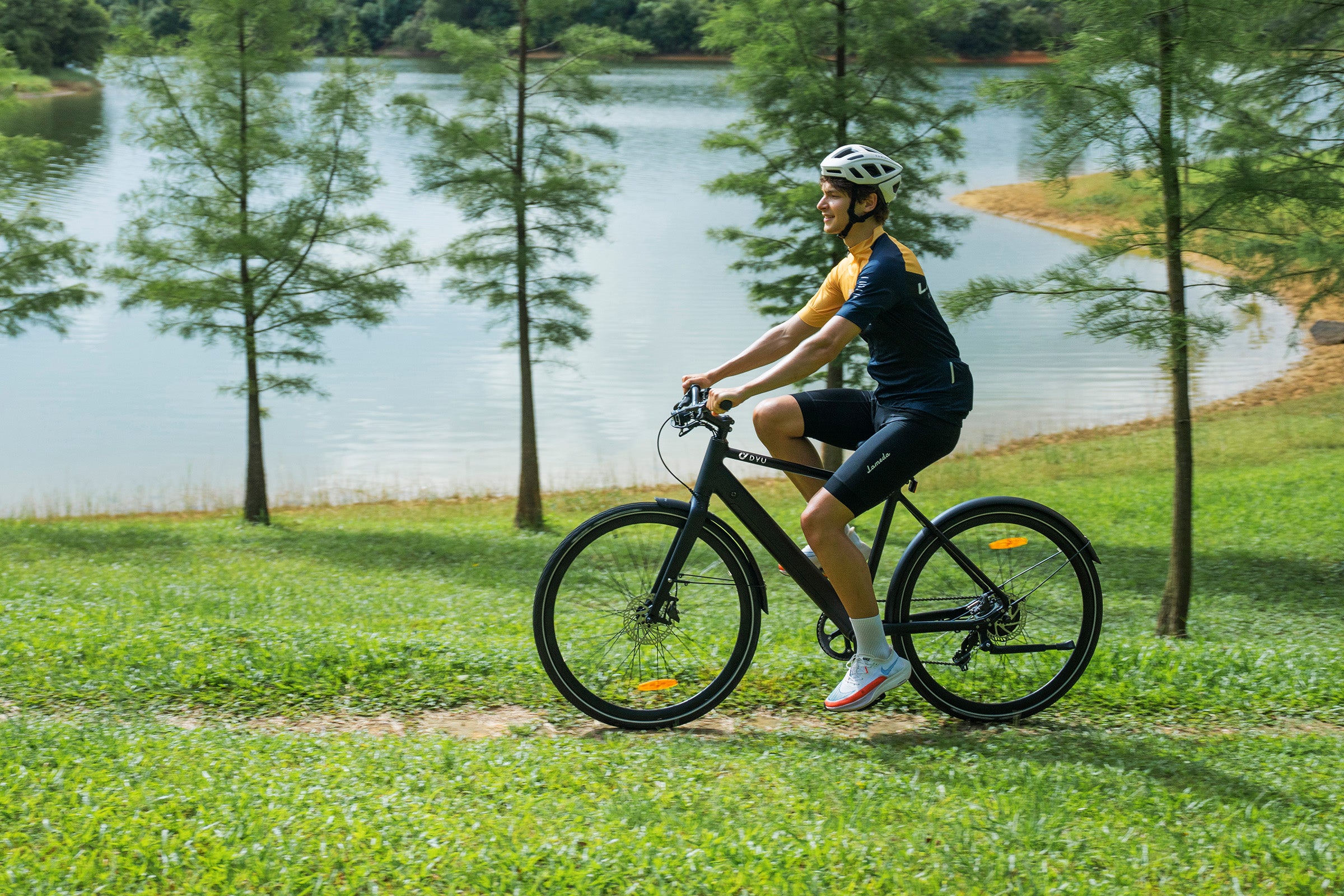 Cyclist enjoying a ride on the DYU Stroll 1 electric bike by a serene lake. Cyclist enjoying a ride on the DYU Stroll 1 electric bike by a serene lake.
