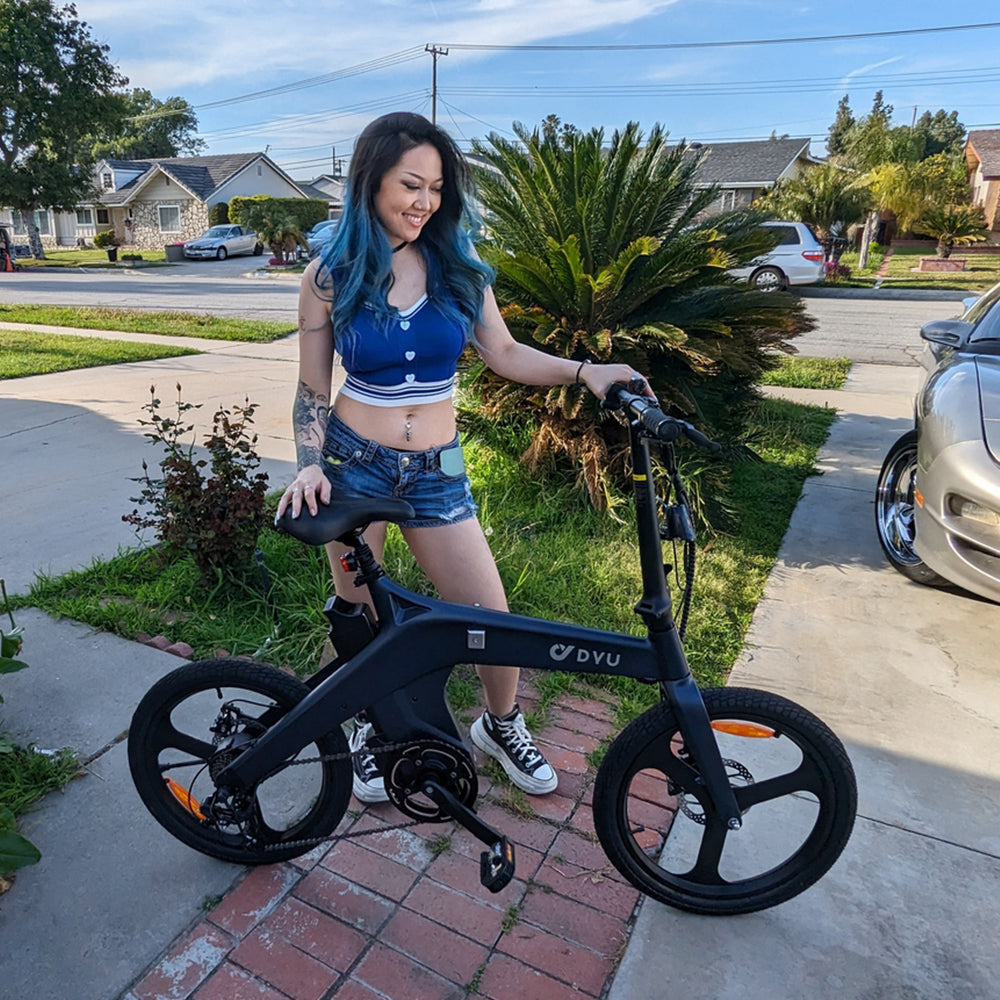 marco trapani is riding a DYU electric bicycle on the road.