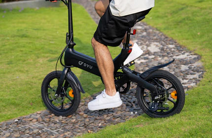 A man riding a black electric bicycle on a stone path.