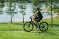 Cyclist enjoying a ride on the DYU Stroll 1 electric bike by a serene lake.